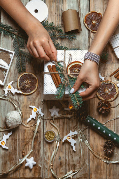 istock Young woman wrapping and decorates christmas present on table wi 1283156941