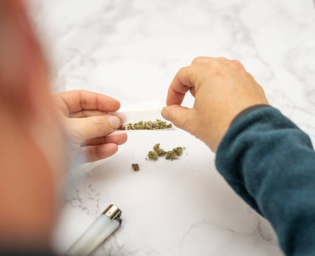 istock View from above of a man preparing a Marijuana and hashish cigar with roller paper 1283164368
