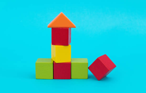 istock Wooden block house on blue background 1283165772