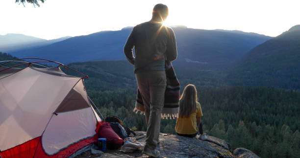 istock Young man brings blanket to girlfriend at campsite 1283165870