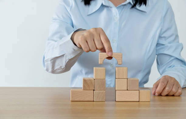istock Businesswoman built a bridge with wooden blocks 1283168708