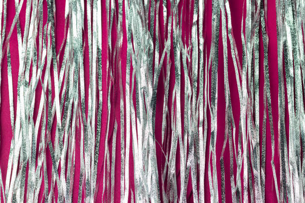 istock Shiny holographic tinsel on dark pink background. Festive or party backdrop. 1283171468
