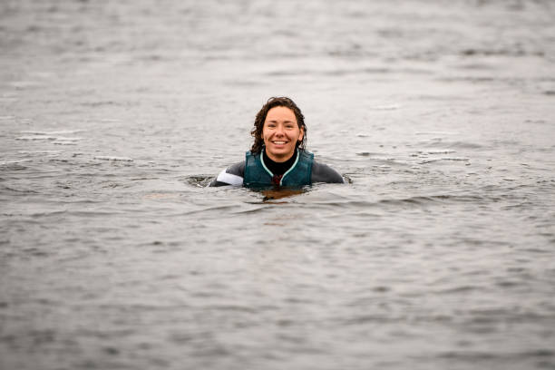 물에 조끼를 입은 잠수복을 입은 젊은 미소 짓는 여성의 모습. - river swimming women water 뉴스 사진 이미지