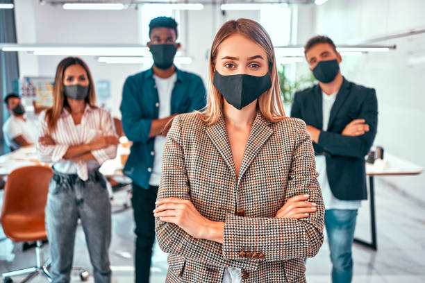 istock Front view of business people wearing protective masks in the office during the quarantine period 1283175372
