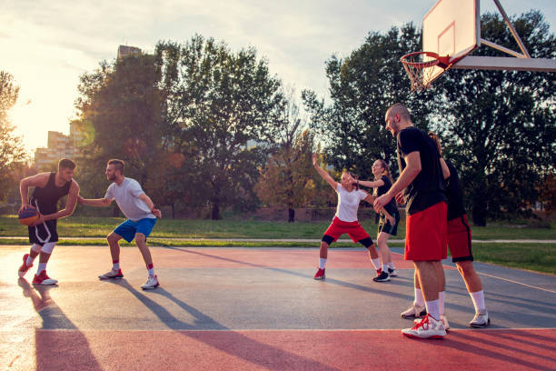 istock Group Of Young Friends Playing Basketball Match 1283176065