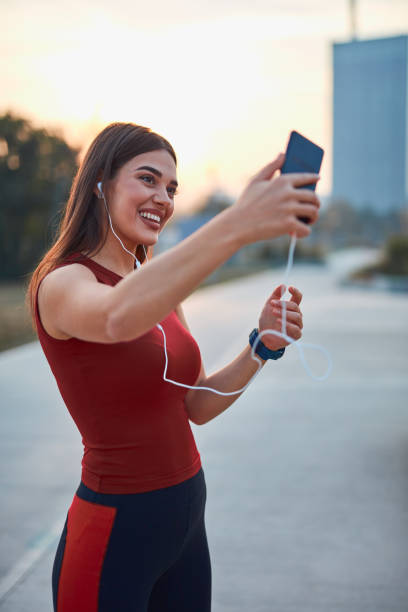 istock Modern young woman with cellphone making pause during jogging / exercise. 1283176379