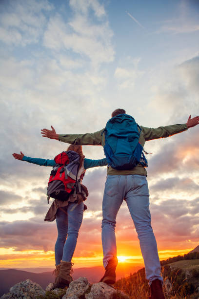 istock Couple on Top of a Mountain Shaking Raised Hands 1283177270