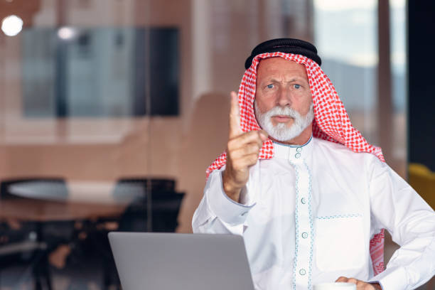 arab businessman points a warning finger at the camera. - headscarf islam senior adult east imagens e fotografias de stock