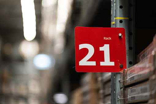 A rack's number sign with blurred background of products shelves in very huge warehouse storage.