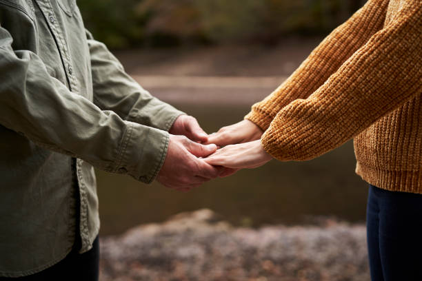 istock Young couple holding hands at the lake. 1283179690