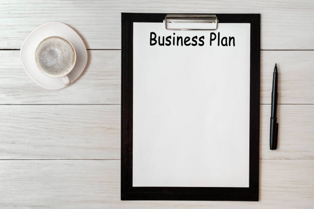 istock Document with title business plan and office supplies and cup of cofee 1283182100