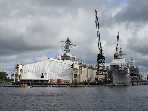Norfolk, USA - June 9, 2019: Image of several US Navy ships docked at BAE Systems Pier in Norfolk for maintenance.