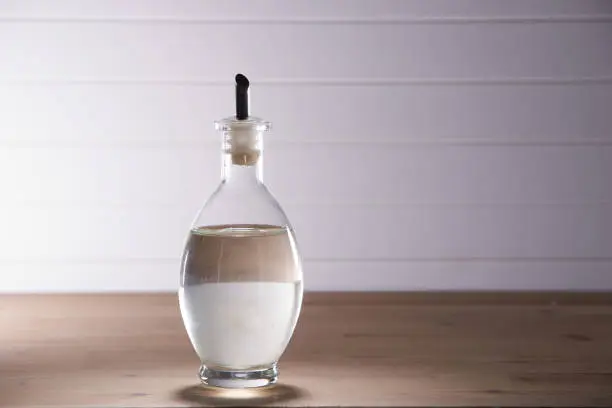 Photo of white vinegar on the wooden table