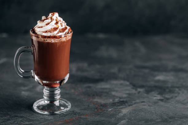 hot chocolate cocoa with whipped cream in glass on dark background, copy space. - latté cafe macchiato cappuccino cocoa imagens e fotografias de stock