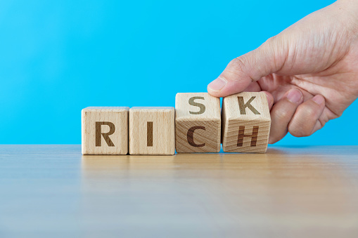Wooden blocks with word risk and rich.