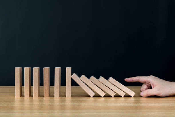 istock Woman hand pushing domino pieces 1283188853