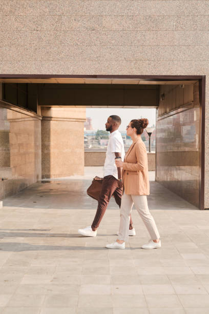 istock Two young intercultural brokers in smart casualwear having talk during walk 1283189226