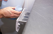 Male hands and washing machine. A man pours a portion of fabric softener. Close-up.