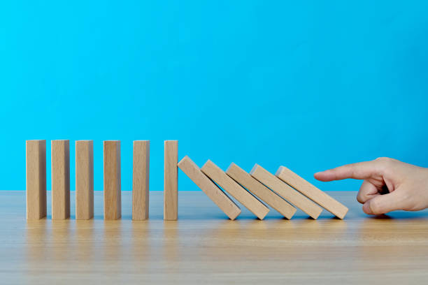 istock Woman hand pushing domino pieces 1283190455