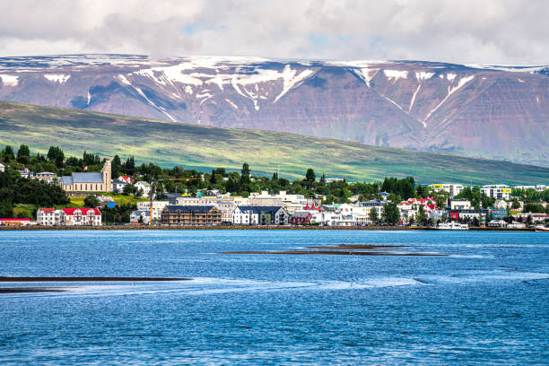 Cityscape skyline of Akureyri with fjord and snow covered mountain peak and houses Akureyri, Iceland - June 17, 2018: Cityscape skyline view of town fishing village with fjord and snow covered mountain peak and houses buildings by water akureyri stock pictures, royalty-free photos & images