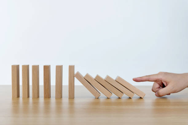 istock Woman hand pushing domino pieces 1283190595