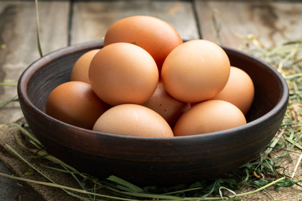 istock Fresh chicken eggs in a clay bowl on the hay. 1283192072