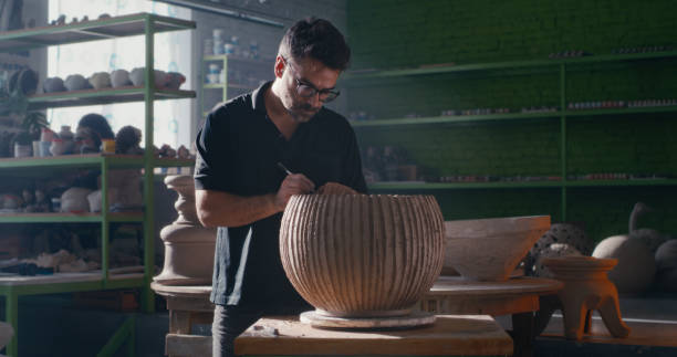 istock Potter creating ornament on clay bowl 1283194094