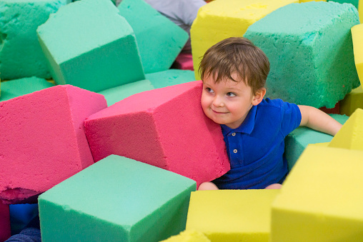 little kid play with soft blocks at indoor children playground