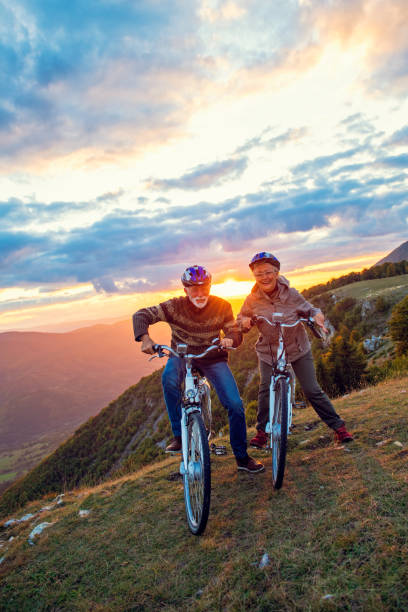 istock Active Senior Couple Riding Bikes In Park 1283202838