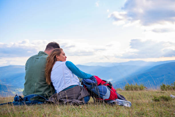 istock Couple Sitting On A Rock Resting During Hike 1283203619