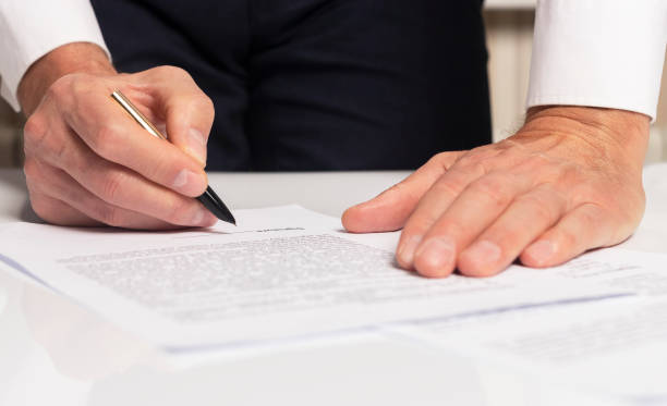 istock Contract signing concept. Businessman hand with pen over document closeup 1283206981
