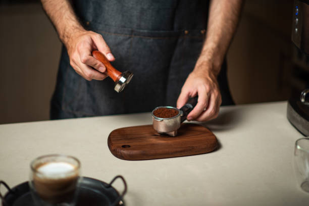 istock Man tampering coffee powder into the portafilter while making coffee 1283207281