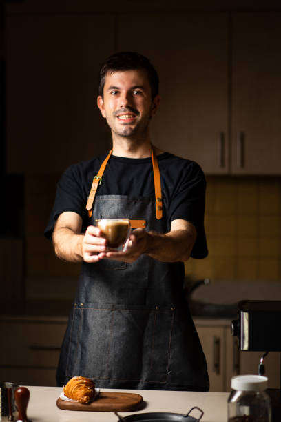 クロワッサン付きのコーヒーを提供する男性バリスタ - latté coffee tray froth ストックフォトと画像