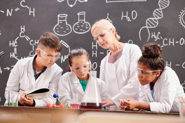istock Several students of secondary school and teacher making chemical experiment 1283210956