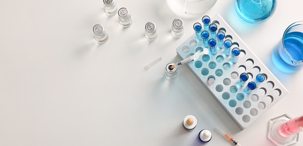 Laboratory bench background with chemical glassware, test tubes, vials and syringes. Top view. Panoramic composition.