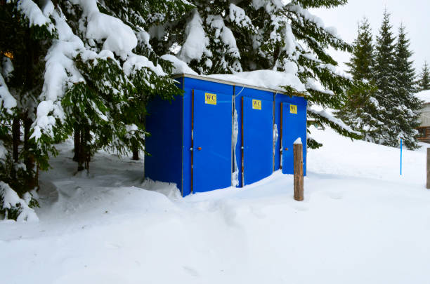 istock Snow-covered, blue, portable toilet on a winter day 1283214524