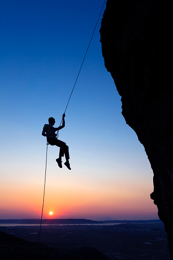 Rock climber bouldering on sunset