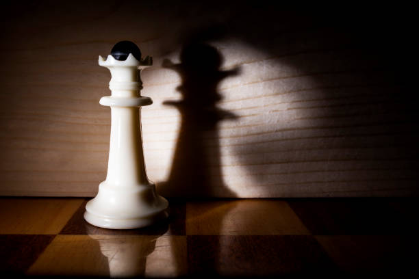 istock queen chess piece casts a shadow on the wooden wall 1283215986
