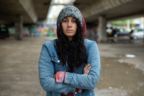 jeune fille ou femme sans-abri déprimée restant seule sous le pont sur la rue sur le temps froid se sentant anxieux abandonné et gelant l’accent sélectif - under the weather photos et images de collection