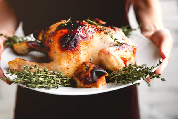 istock Woman holding plate with delicious roasted chicken 1283218810