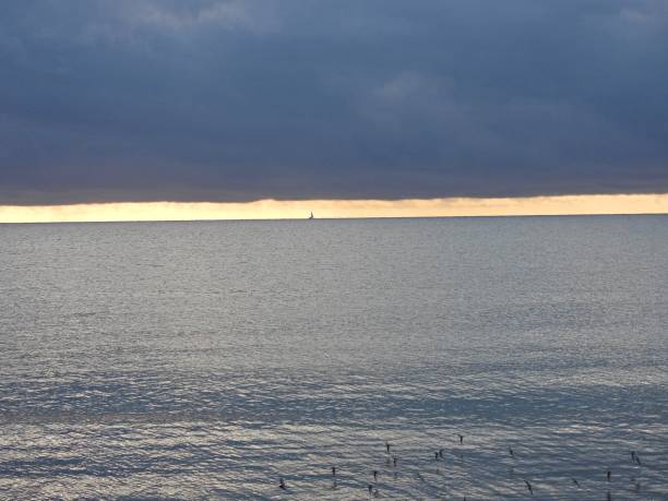 sonnenaufgang mit einem segelboot am horizont - floridas atlantik - sky dramatic sky cloudscape passion stock-fotos und bilder