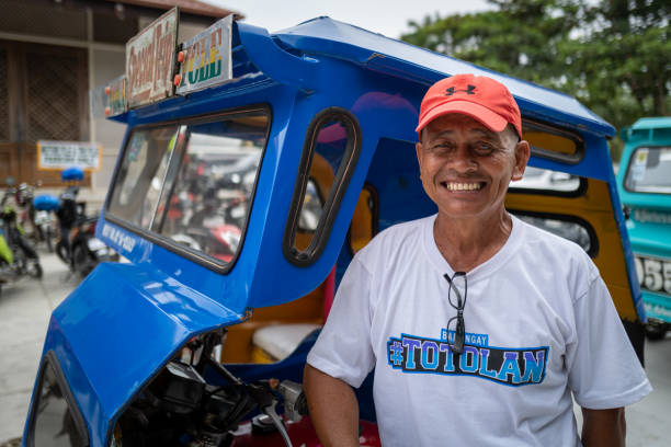 Bohol, Philippines - September 11 2019: A tricycle driver smiling at the camera. Bohol, Philippines - September 11 2019: A tricycle driver smiling at the camera philippines tricycle stock pictures, royalty-free photos & images