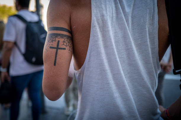 A young man with cross tattoo on the streets of Barcelona. Barcelona, Spain - September 03 2019: A young man with cross tattoo on the streets of Barcelona cross shoulder tattoos stock pictures, royalty-free photos & images