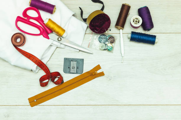 istock sewing tools : scissors, colorful bobbins with thread and presser foot on  wooden table 1283219987