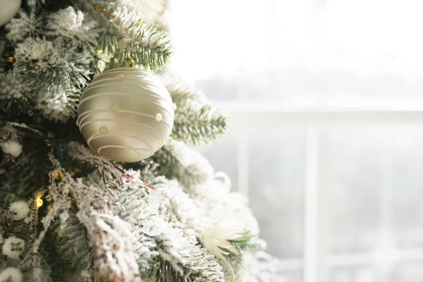 nowy rok wakacje praparacji i uroczystości. srebrna kula na sosnie bożonarodzeniowym przy oknie świetlnym, widok z bliska - christmas window magic house zdjęcia i obrazy z banku zdjęć
