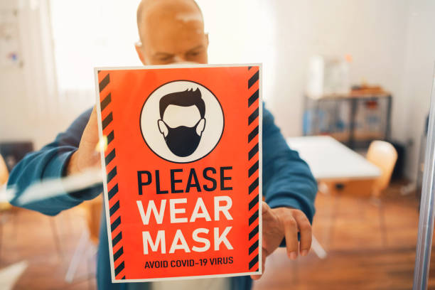 istock Please wear mask sign attached by man at office 1283221302