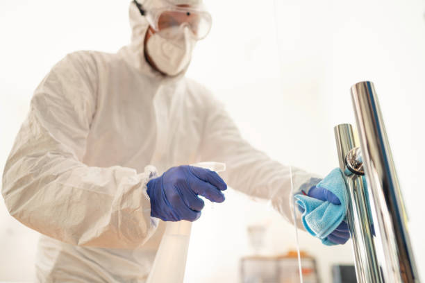 istock Unrecognizable man spraying and disinfecting door handle at an office 1283221371