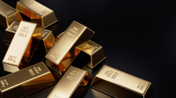 istock Gold Bars Laying on Black Background 1283221652