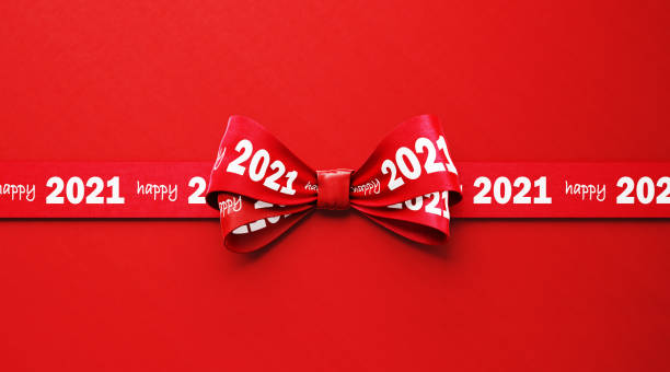 istock Happy 2021 Written Red Ribbon Sitting over Red Background 1283222662