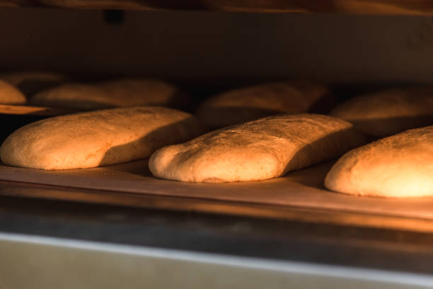 istock Making craft bread at the bakery. Close-up of a baker and bread, blurred background 1283224291